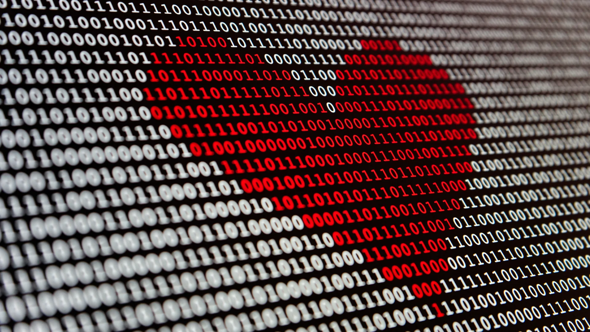 Bild von einem Bildschirm, auf dem ein rotes Herz durch den Zahlencode 1 und 0 erstellt wird.